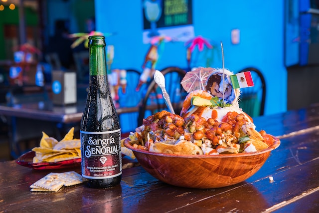 Brown wooden bowl with chips and bottle